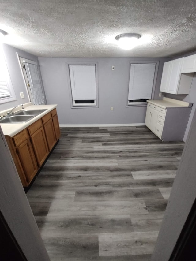 kitchen featuring a textured ceiling, white cabinets, sink, and dark wood-type flooring