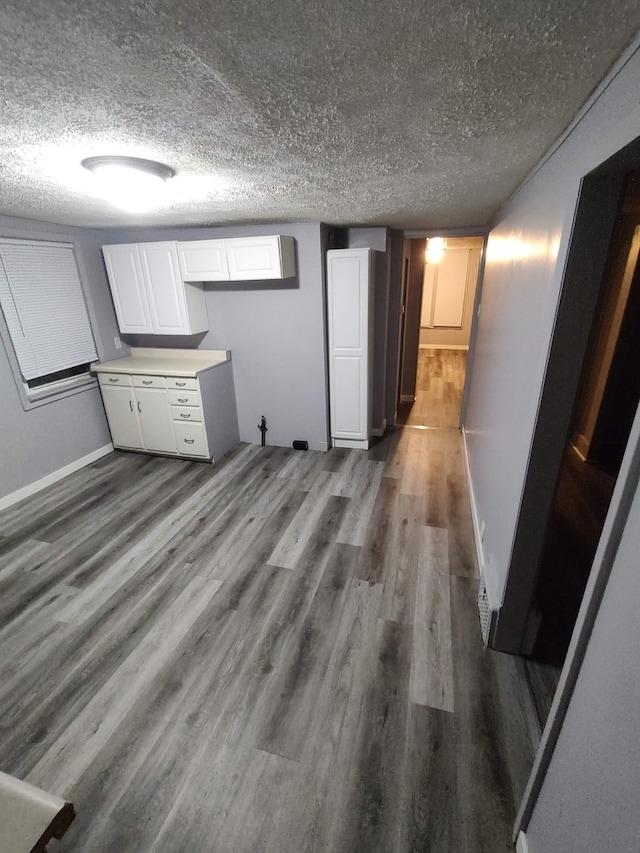 interior space featuring white cabinetry, a textured ceiling, and dark hardwood / wood-style floors