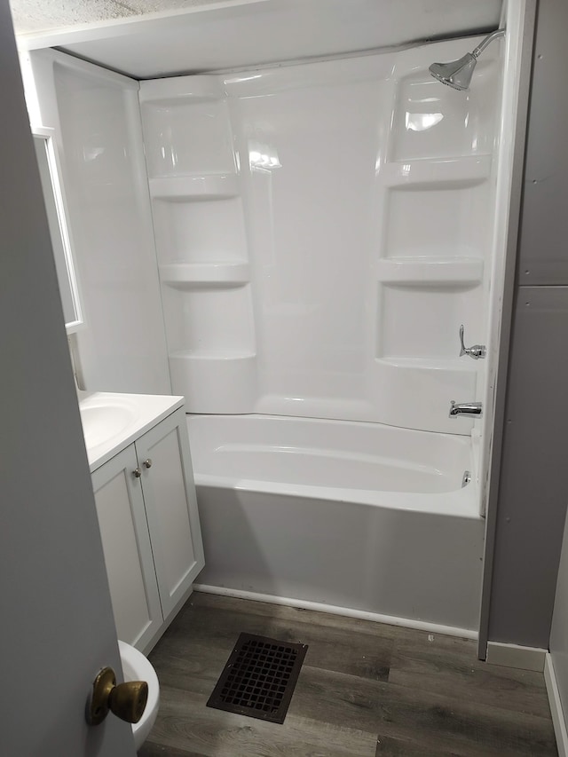 bathroom featuring vanity, wood-type flooring, and washtub / shower combination