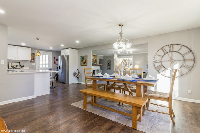 dining room with dark wood-type flooring and an inviting chandelier