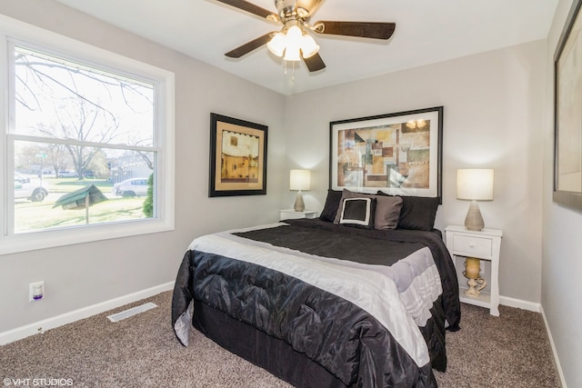 bedroom with ceiling fan, multiple windows, and carpet