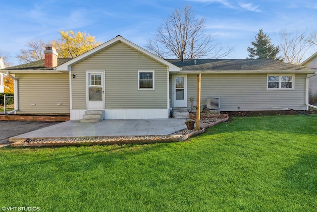 rear view of property with a lawn, central AC, and a patio