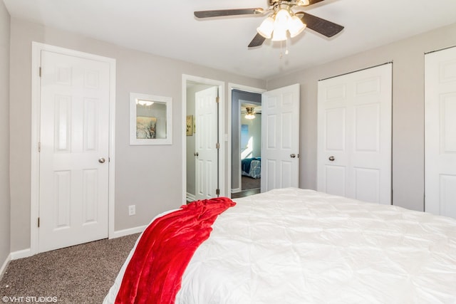 carpeted bedroom featuring multiple closets and ceiling fan