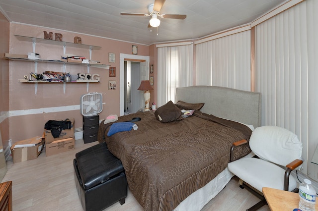 bedroom featuring ceiling fan, crown molding, and light wood-type flooring