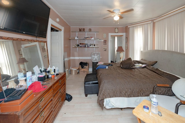 bedroom with ornamental molding, light wood-type flooring, and ceiling fan