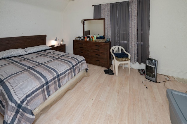 bedroom with light hardwood / wood-style floors and heating unit