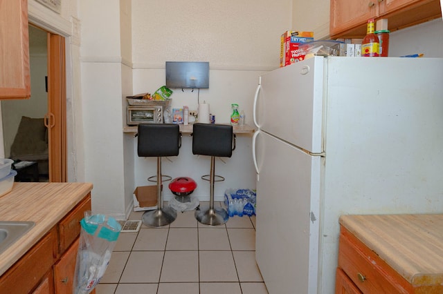 kitchen featuring light tile patterned flooring and white refrigerator