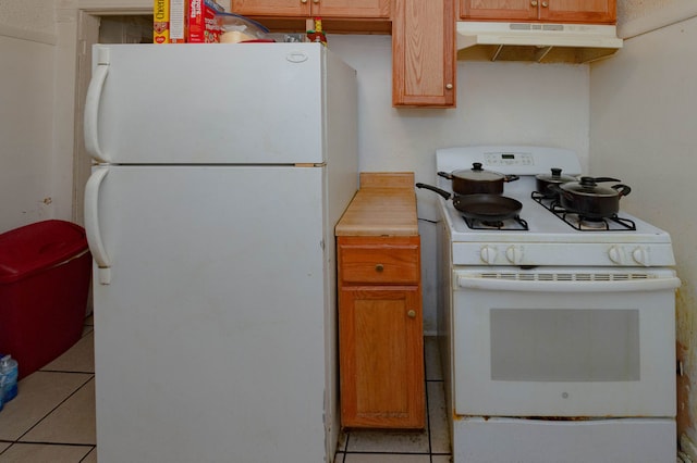 kitchen featuring white appliances and light tile patterned flooring