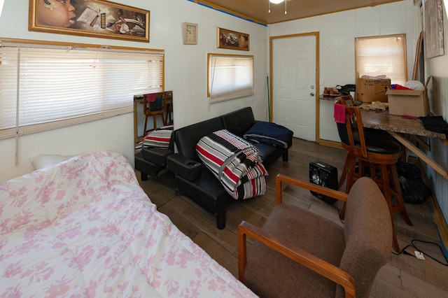 bedroom with ornamental molding, multiple windows, and dark hardwood / wood-style floors