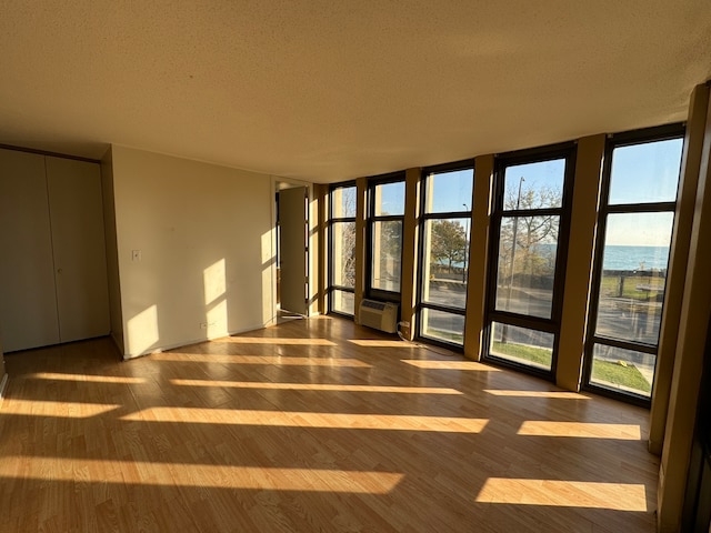 spare room featuring hardwood / wood-style floors, a water view, and plenty of natural light