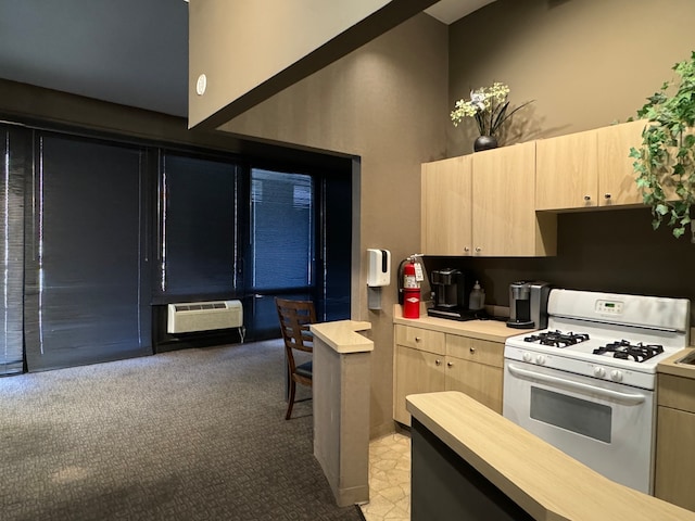 kitchen with white gas range, light carpet, light brown cabinets, and a wall unit AC