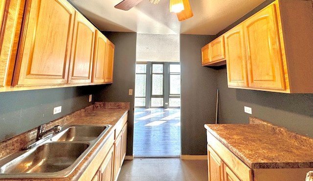 kitchen featuring ceiling fan, light brown cabinetry, and sink