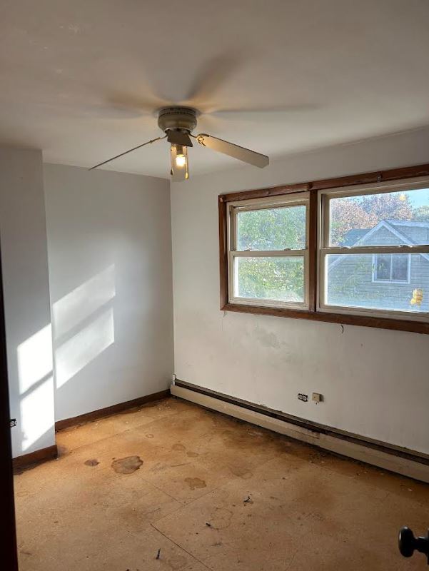 spare room featuring baseboard heating and ceiling fan