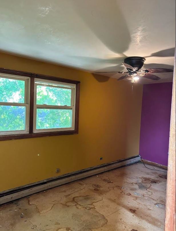 spare room with ceiling fan and a baseboard heating unit