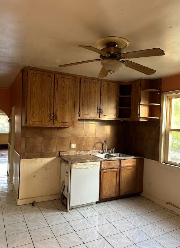 kitchen with decorative backsplash, sink, white dishwasher, and ceiling fan