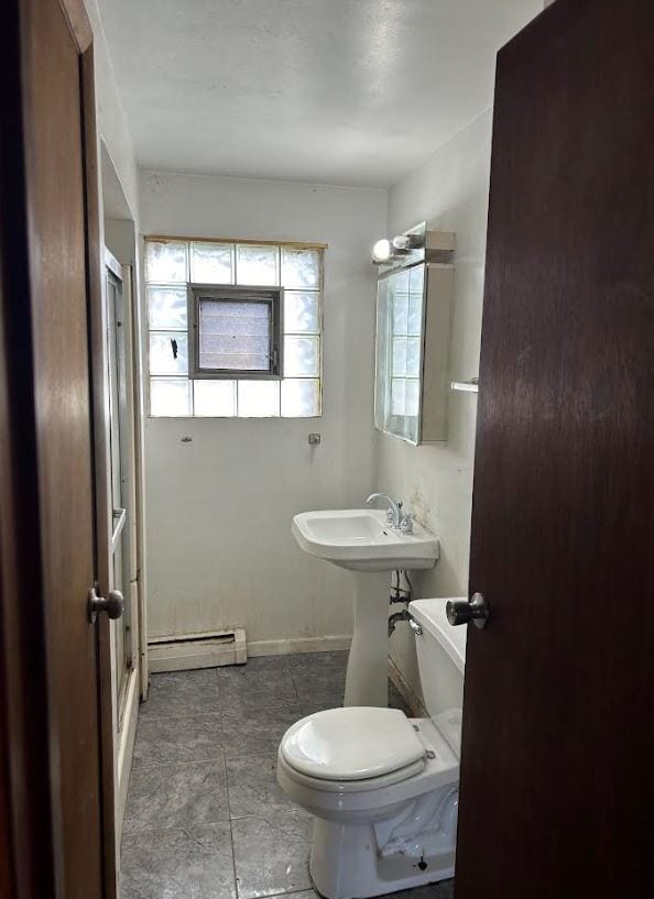 bathroom featuring toilet and a baseboard heating unit