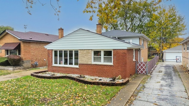 view of side of property featuring a garage, a yard, and an outdoor structure