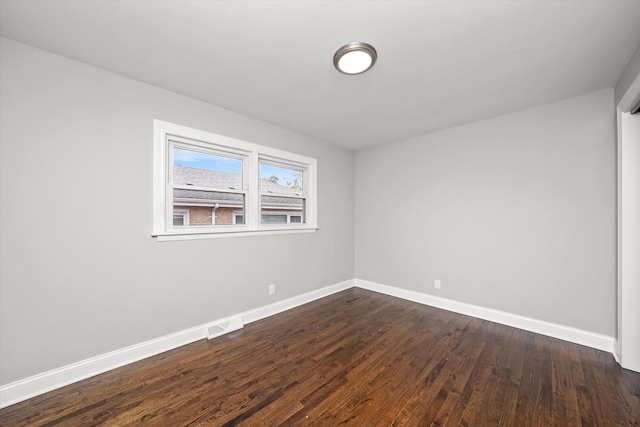 spare room with dark wood-type flooring