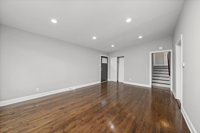 empty room with dark hardwood / wood-style floors and lofted ceiling