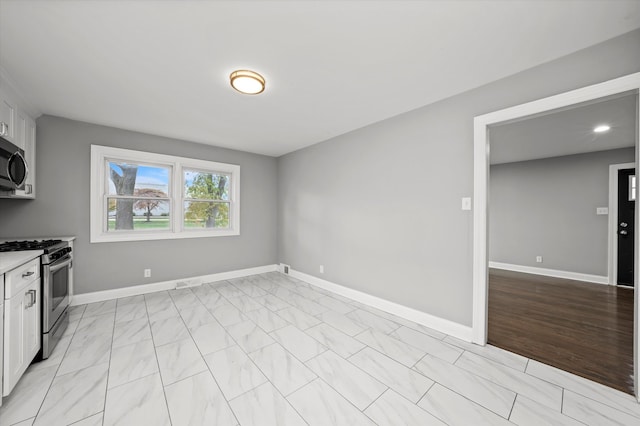 kitchen featuring white cabinets, stainless steel appliances, and light hardwood / wood-style flooring