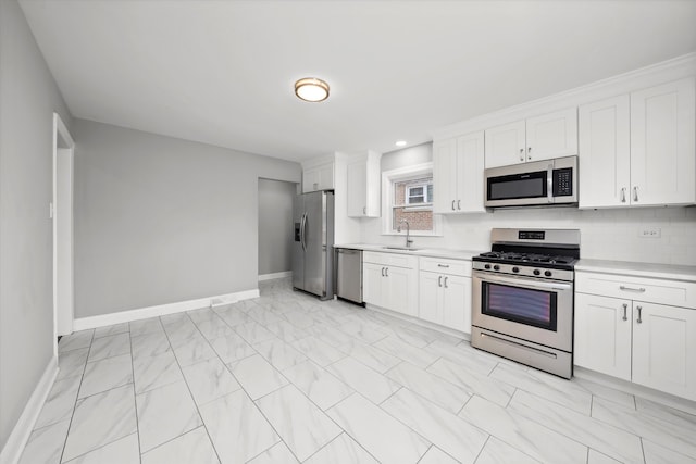 kitchen featuring white cabinets, stainless steel appliances, sink, and backsplash