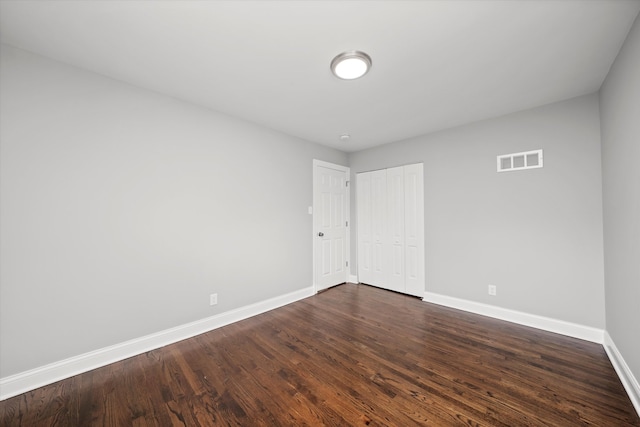 empty room with dark wood-type flooring