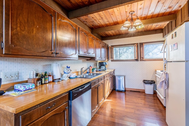 kitchen featuring a sink, white appliances, wooden counters, and wallpapered walls