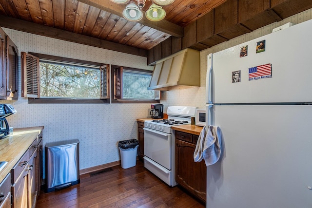 kitchen with visible vents, custom range hood, white appliances, wallpapered walls, and wooden counters