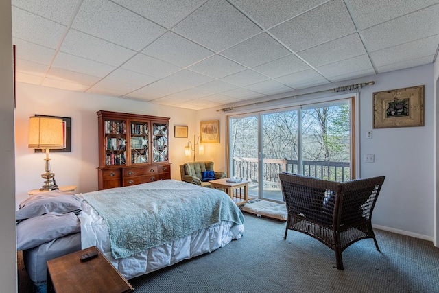 bedroom featuring access to exterior, a paneled ceiling, baseboards, and carpet floors