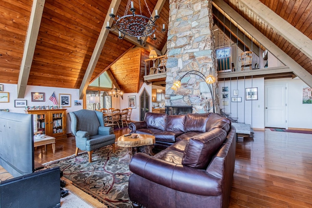 living area with baseboards, a fireplace, hardwood / wood-style flooring, beamed ceiling, and a notable chandelier