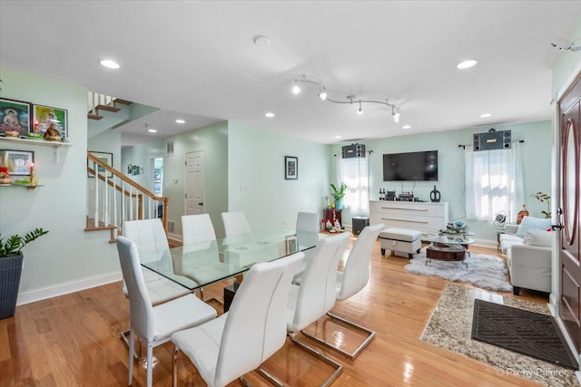 dining area featuring recessed lighting, baseboards, wood finished floors, and stairs