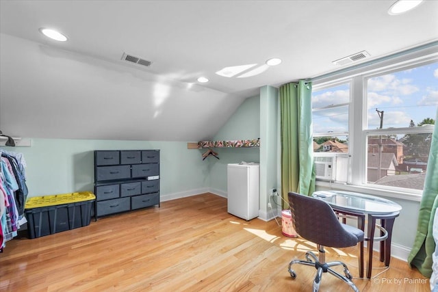 home office with vaulted ceiling, visible vents, baseboards, and wood finished floors