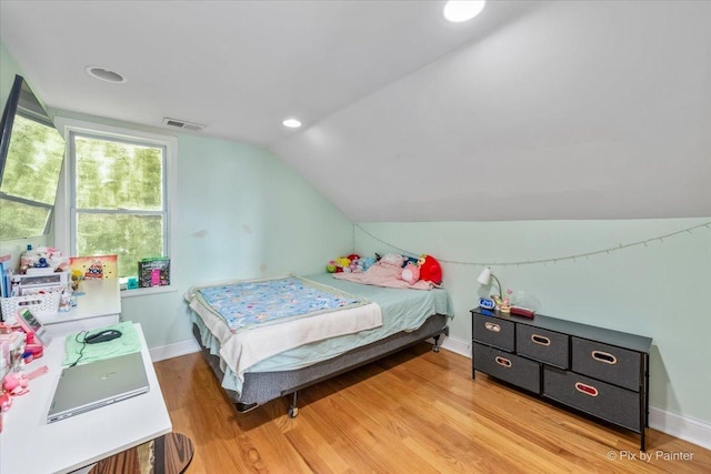 bedroom featuring visible vents, baseboards, light wood-type flooring, and lofted ceiling