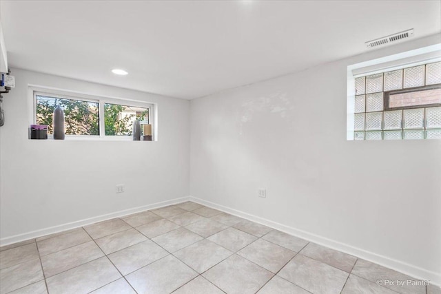 unfurnished room with light tile patterned floors, visible vents, and baseboards