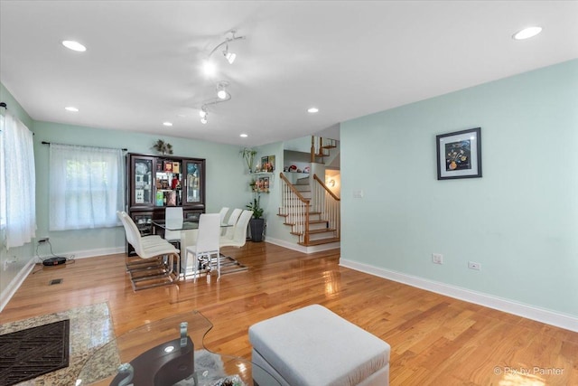 living area featuring recessed lighting, baseboards, wood finished floors, and stairs