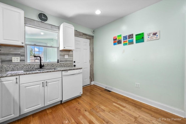 kitchen with light wood-style flooring, a sink, backsplash, white cabinetry, and dishwasher