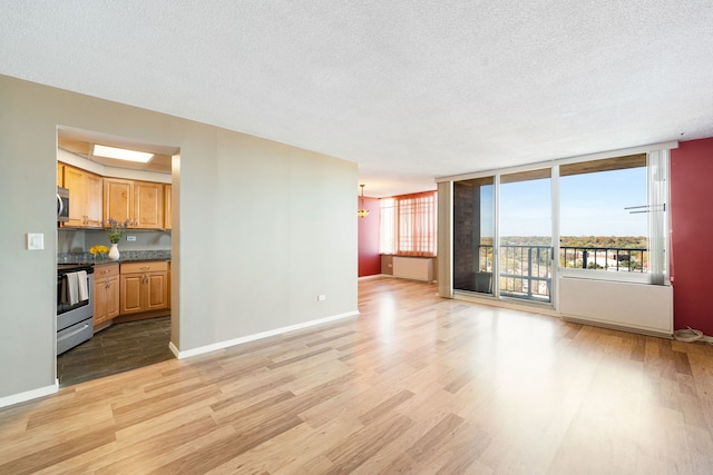 unfurnished living room featuring light hardwood / wood-style flooring and a textured ceiling