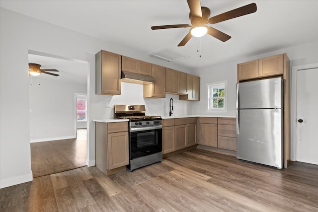 kitchen with sink, ceiling fan, stainless steel appliances, and hardwood / wood-style flooring