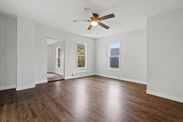 empty room with a baseboard heating unit, ceiling fan, and dark hardwood / wood-style flooring