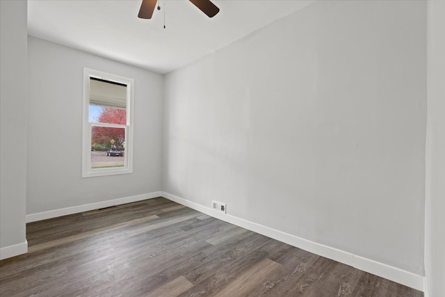 empty room with ceiling fan and dark hardwood / wood-style flooring