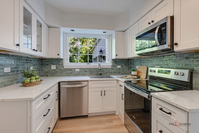 kitchen featuring a wealth of natural light, white cabinetry, and appliances with stainless steel finishes