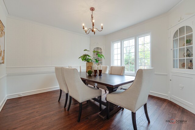 dining space with dark hardwood / wood-style floors, ornamental molding, and a notable chandelier