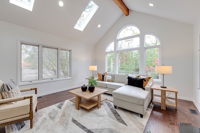 living room featuring a skylight, beamed ceiling, light hardwood / wood-style floors, and high vaulted ceiling