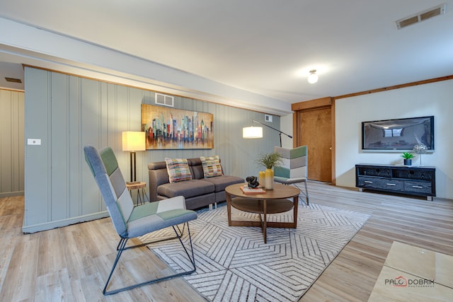 living room featuring crown molding and light wood-type flooring