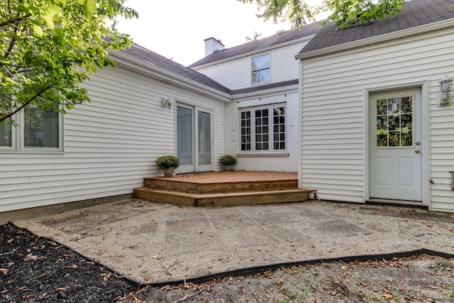 entrance to property featuring a patio area and a wooden deck