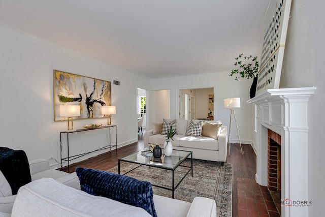 living room featuring dark wood-type flooring, a brick fireplace, and ornamental molding