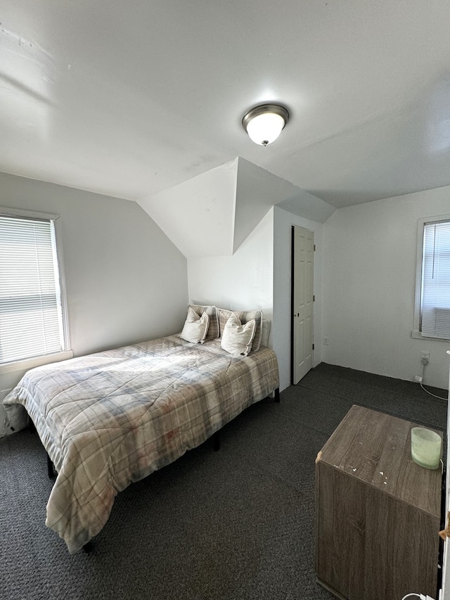 bedroom featuring lofted ceiling and dark colored carpet