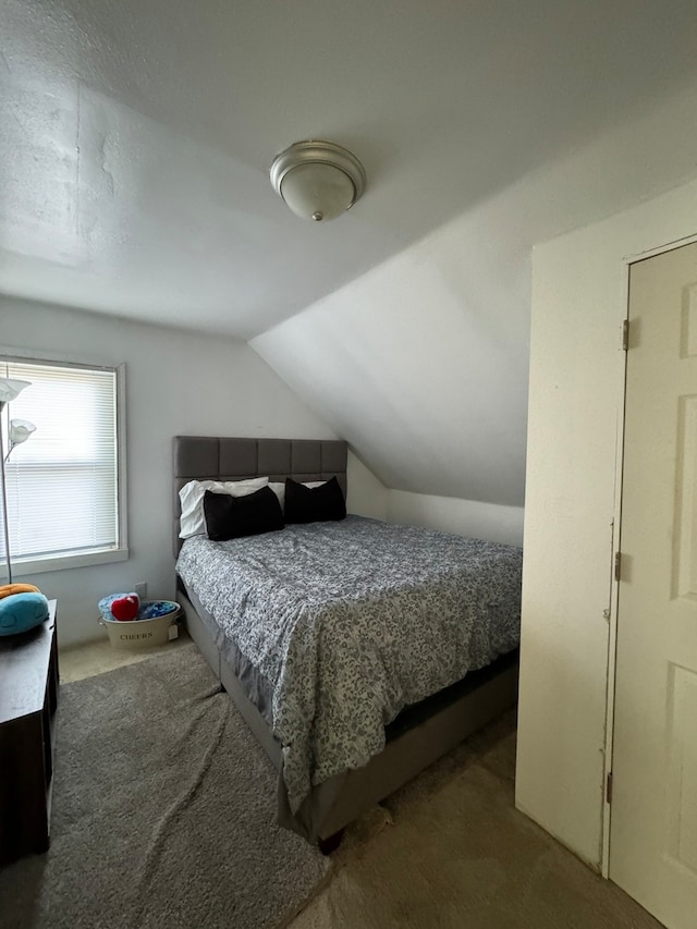 carpeted bedroom with lofted ceiling