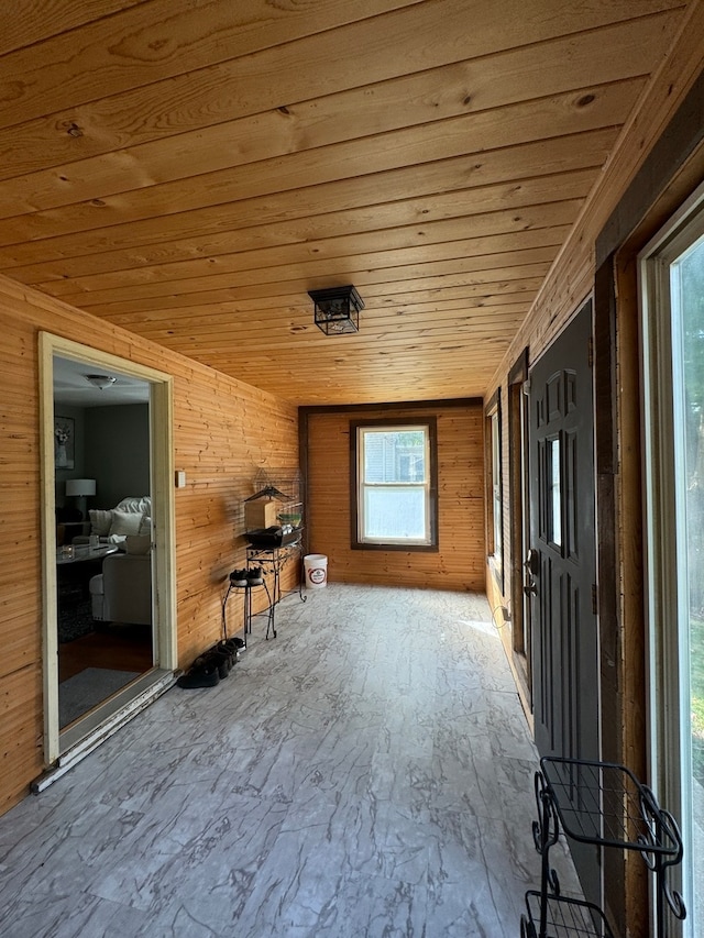 interior space featuring wood walls, a healthy amount of sunlight, and wooden ceiling