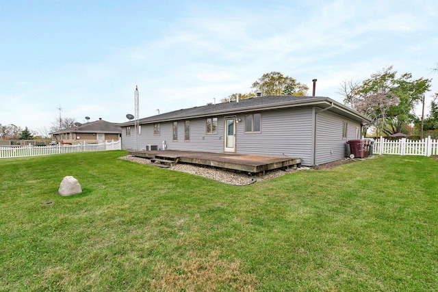 back of property with a wooden deck and a yard